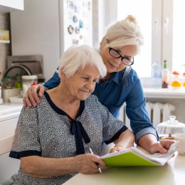 Senior female and her daughter going over financial paperwork